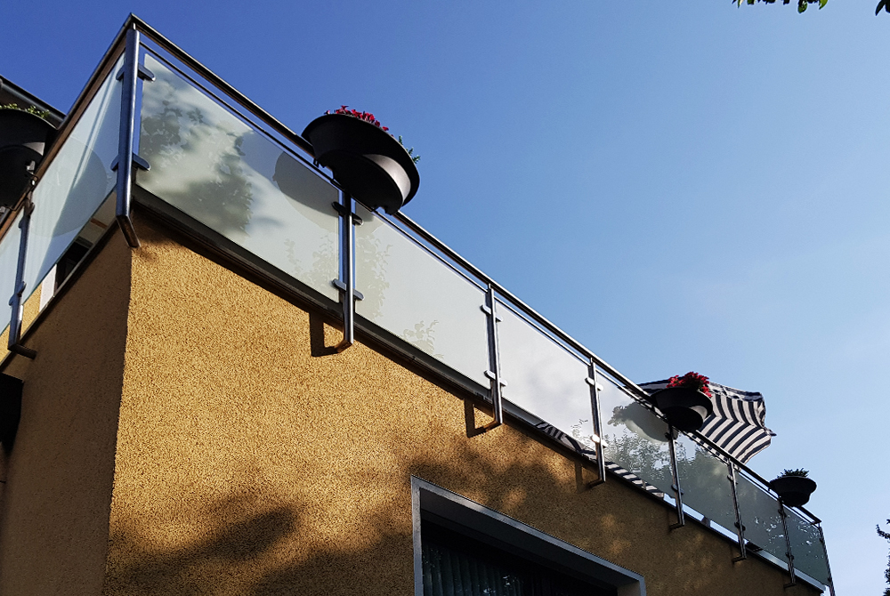 Edelstahlschlosserei Nappenfeld aus Mühlheim realisierte ein neues Geländer mit matt-weißem Sicherheitsglas auf dem Balkon eines Einfamilienhauses in Essen