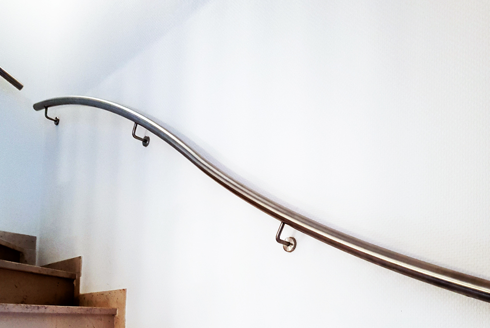Für ein Einfamilienhaus in Dinslaken realisierte Nappenfeld ein Edelstahl-Harfengeländer und einen Edelstahl-Handlauf, der dem geschwungenen Treppenlauf angepasst ist