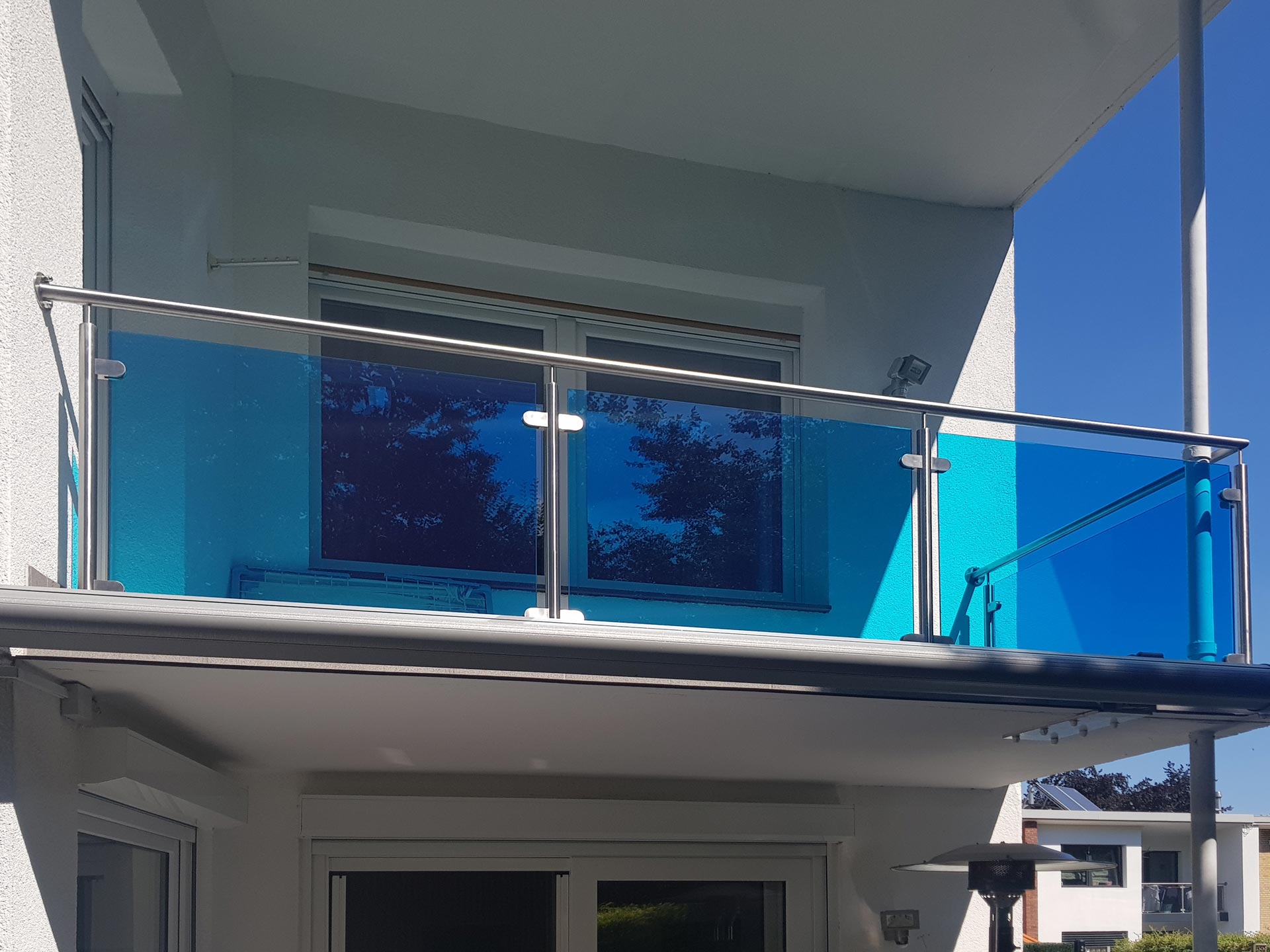 Balkon mit blauem Glas in Düsseldorf, geplant und umgesetzt von der Edelstahlschlosserei Nappenfeld aus Mülheim