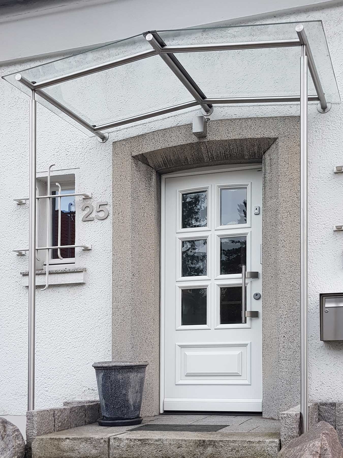 Vordach aus Glas und Edelstahl in Ratingen, gebaut und umgesetzt von der Edelstahlschlosserei Nappenfeld aus Mülheim