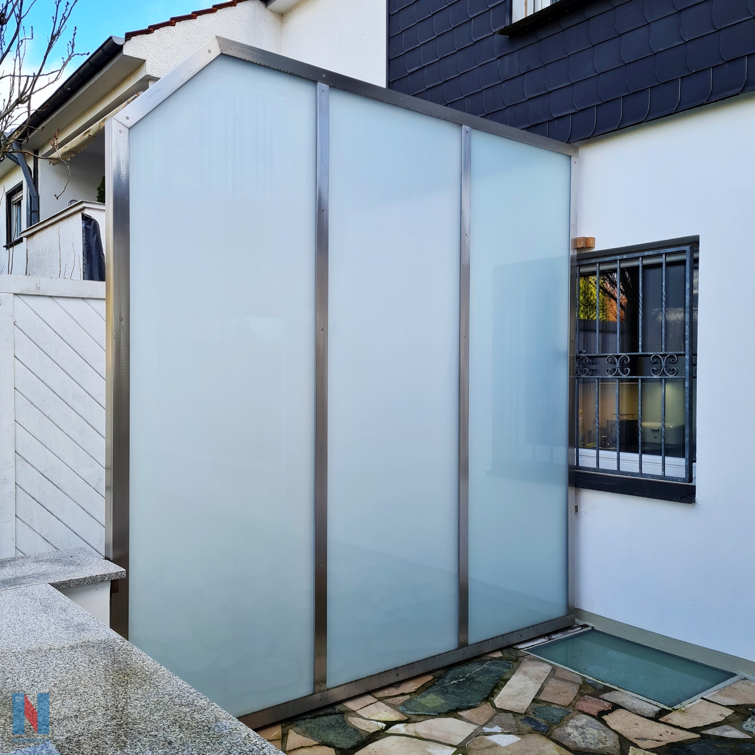 In Mülheim an der Ruhr haben die Edelstahlschlosser eine Trennwand aus Milch-glas errichtet, eingefasst von einem Rahmen aus Edelstahl