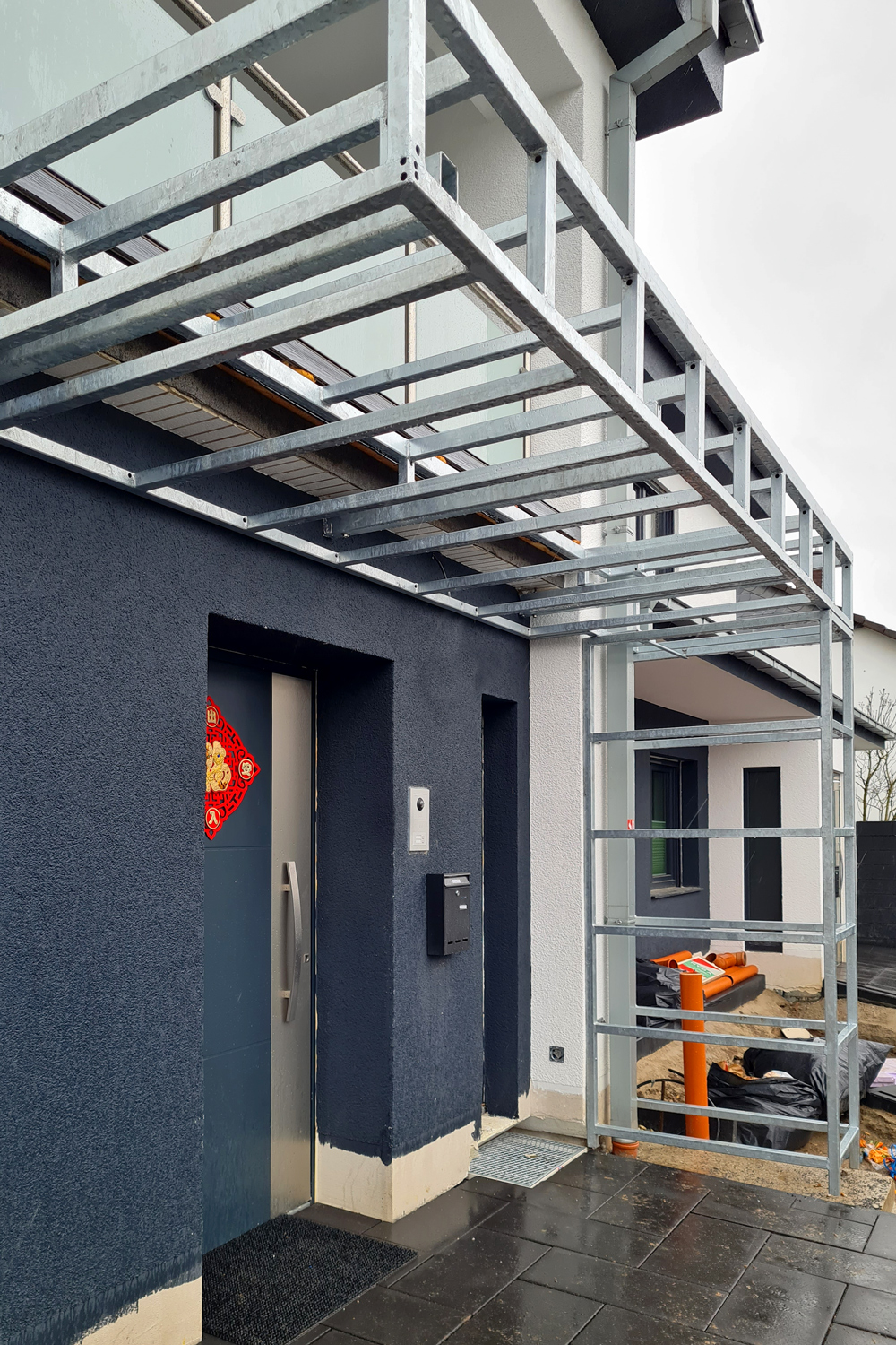 Edelstahlschlosserei verwandelt eine eckige Stahlkonstruktion in ein modernes Vordach in Düsseldorf