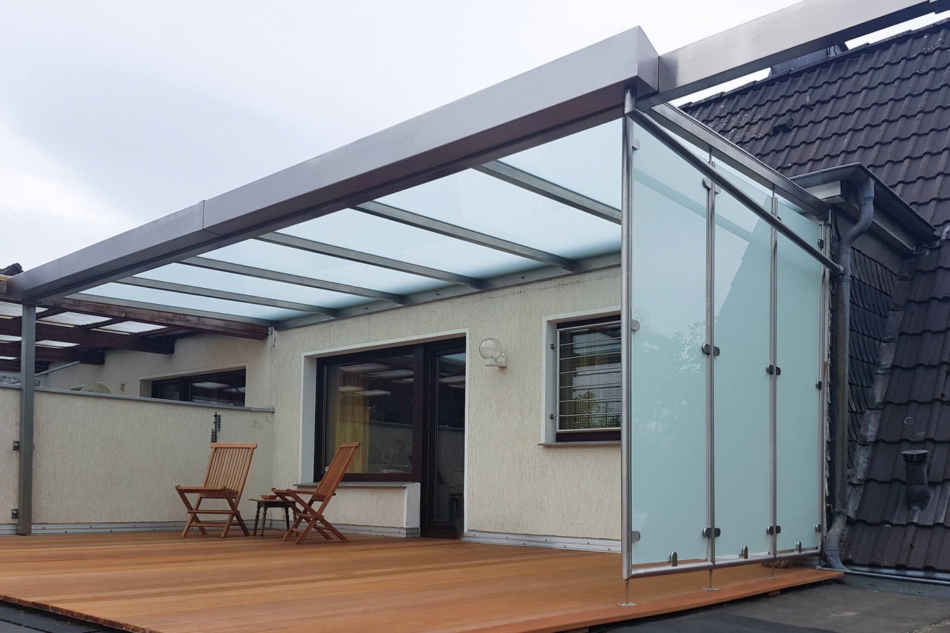 Der Edelstahl-Experte Nappenfeld aus Mühlheim montierte auf die Terrasse eines Mehrfamilienhauses ein Dach samt Seitenwände aus Milchglas.